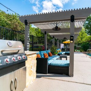 Grilling area and pool seating at SoNA Apartments
